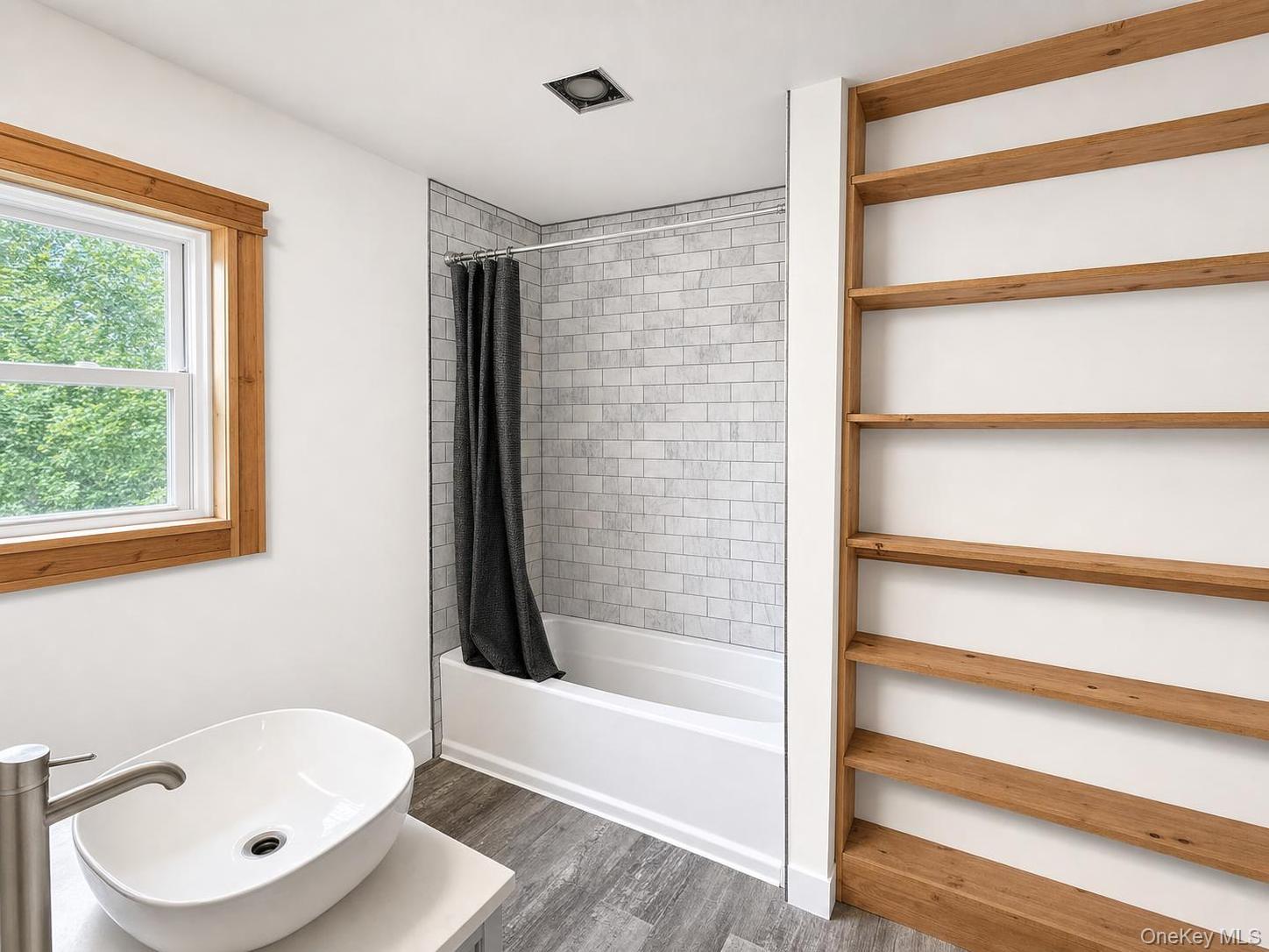 150 Cold Spring Road Liberty, NY 12754 - Photo 19 of 25 Bathroom featuring a white vessel sink, brushed nickel faucet, wood-finish flooring, built-in open shelving, and a tiled shower-tub combination