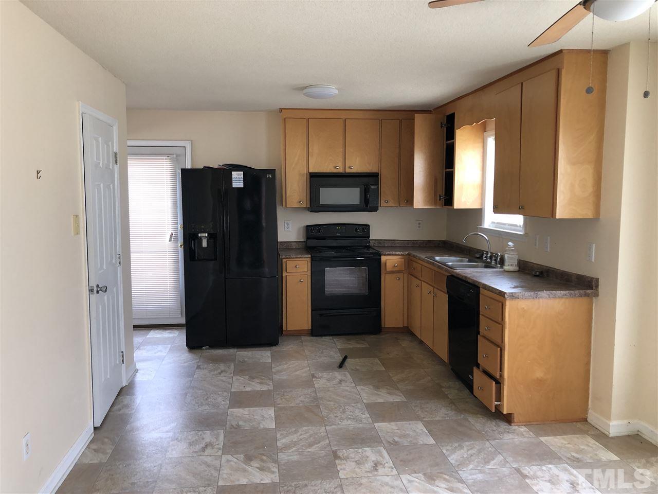 587 Rock Pillar Road Clayton, NC 27520 - Photo 6 of 12 a kitchen with granite countertop a refrigerator and a stove top oven