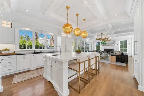 a kitchen with stainless steel appliances kitchen island granite countertop a stove a sink a refrigerator and white cabinets with wooden floor