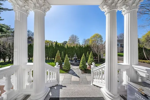 a view of a porch with couches potted plants and wooden floor
