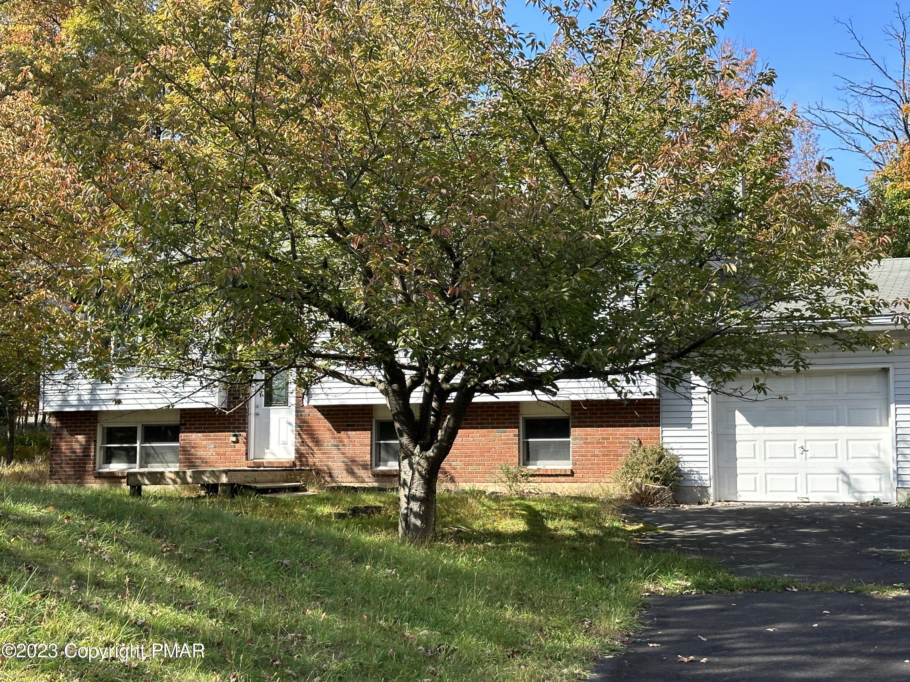 4215 Pine Ridge Drive East Bushkill, PA 18324 - Photo 1 of 18 a front view of a house with a garden