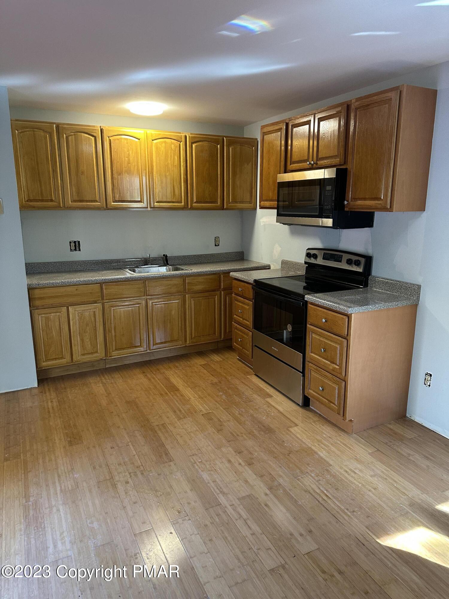 4215 Pine Ridge Drive East Bushkill, PA 18324 - Photo 5 of 18 a kitchen with stainless steel appliances granite countertop wooden cabinets a stove top oven a sink and dishwasher