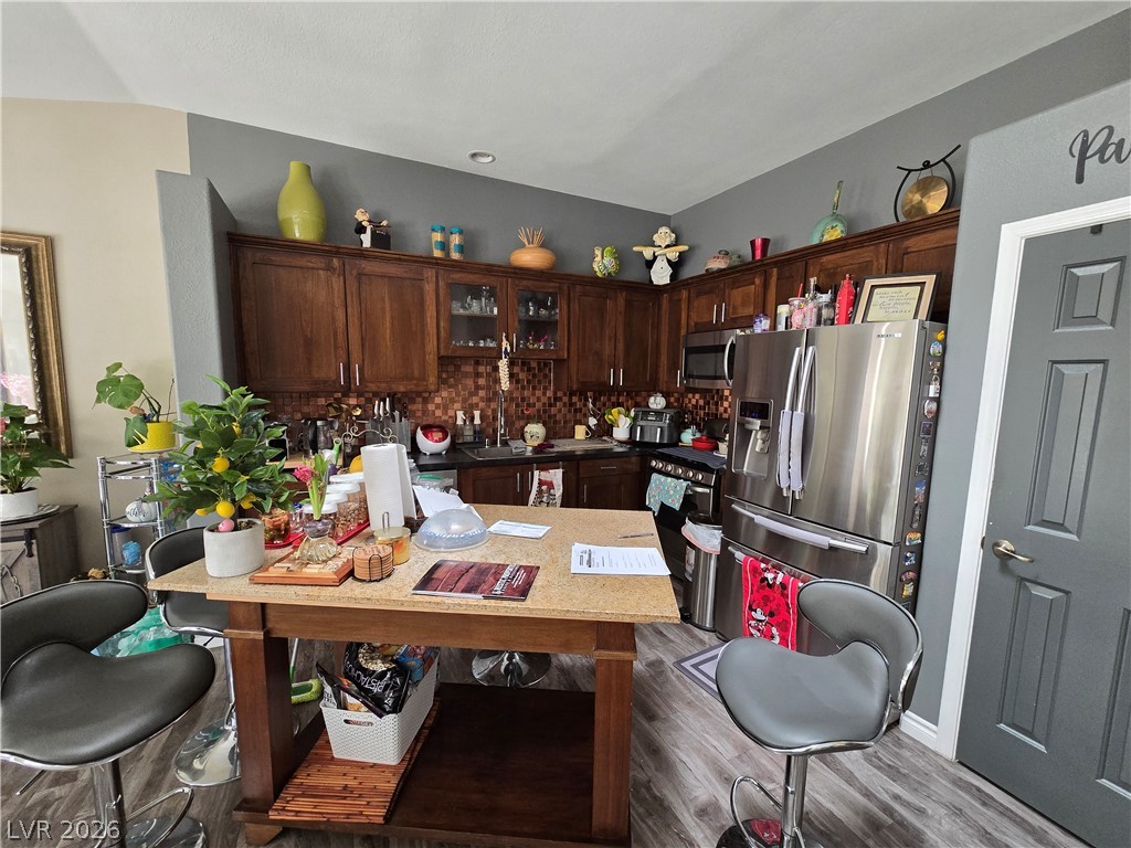 415 Golden State Street Henderson, NV 89012 - Photo 2 of 11 Rich wood cabinets and stone counters define this functional kitchen workspace.