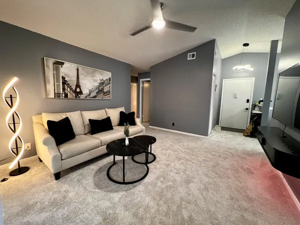a living room with furniture a couch and a chandelier