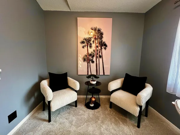 a living room with furniture and a wall painting