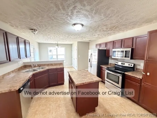 a kitchen with stainless steel appliances granite countertop a sink and a stove