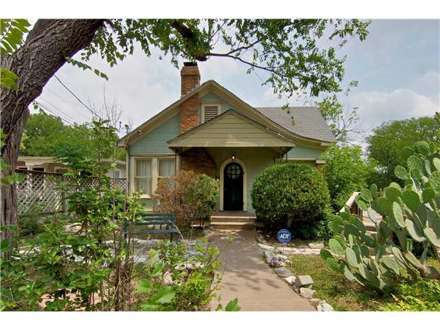a front view of a house with a yard and potted plants