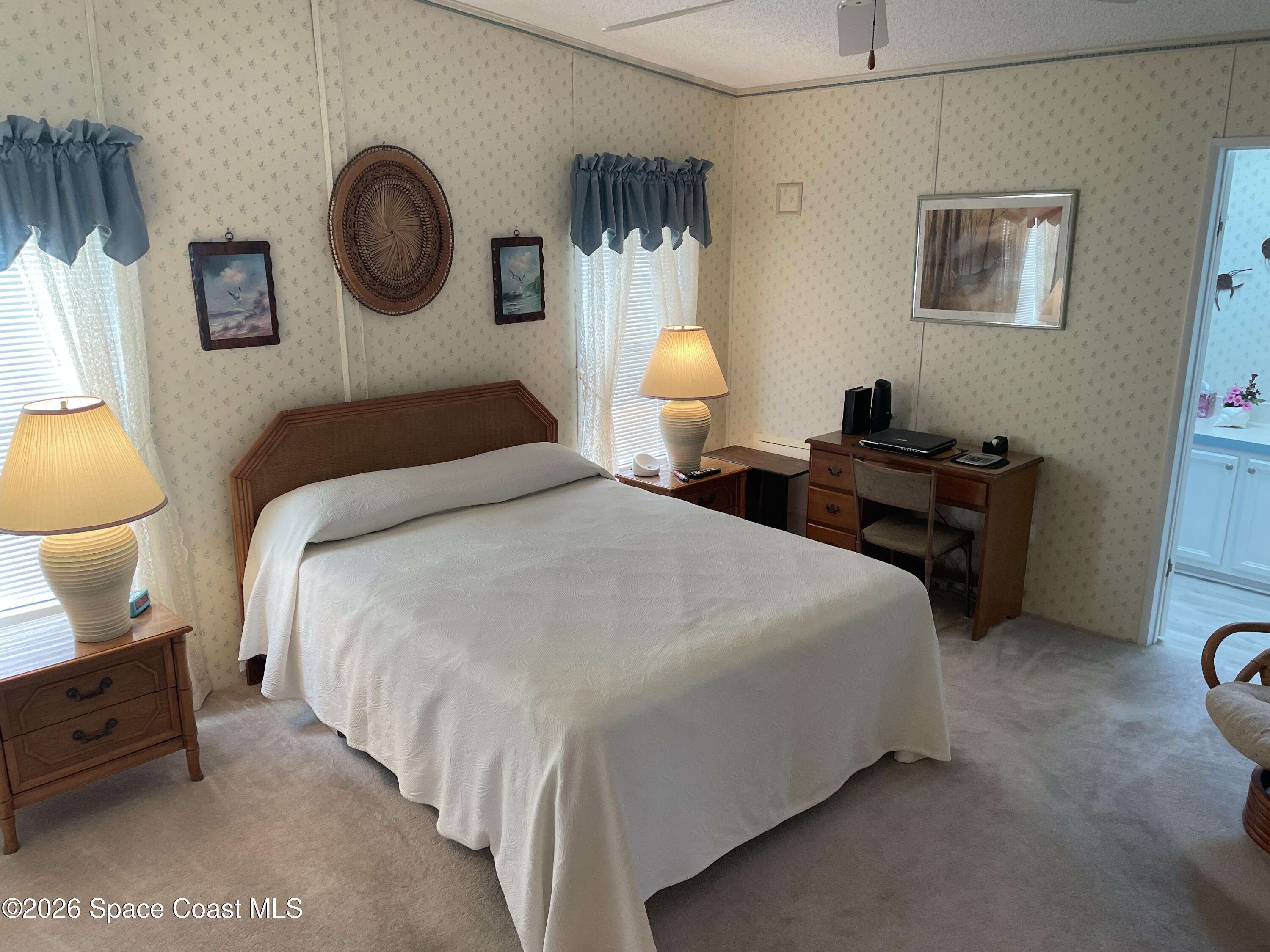 7579 Boxelder Road Micco, FL 32976 - Photo 11 of 30 a bedroom with a bed and a lamp on dresser