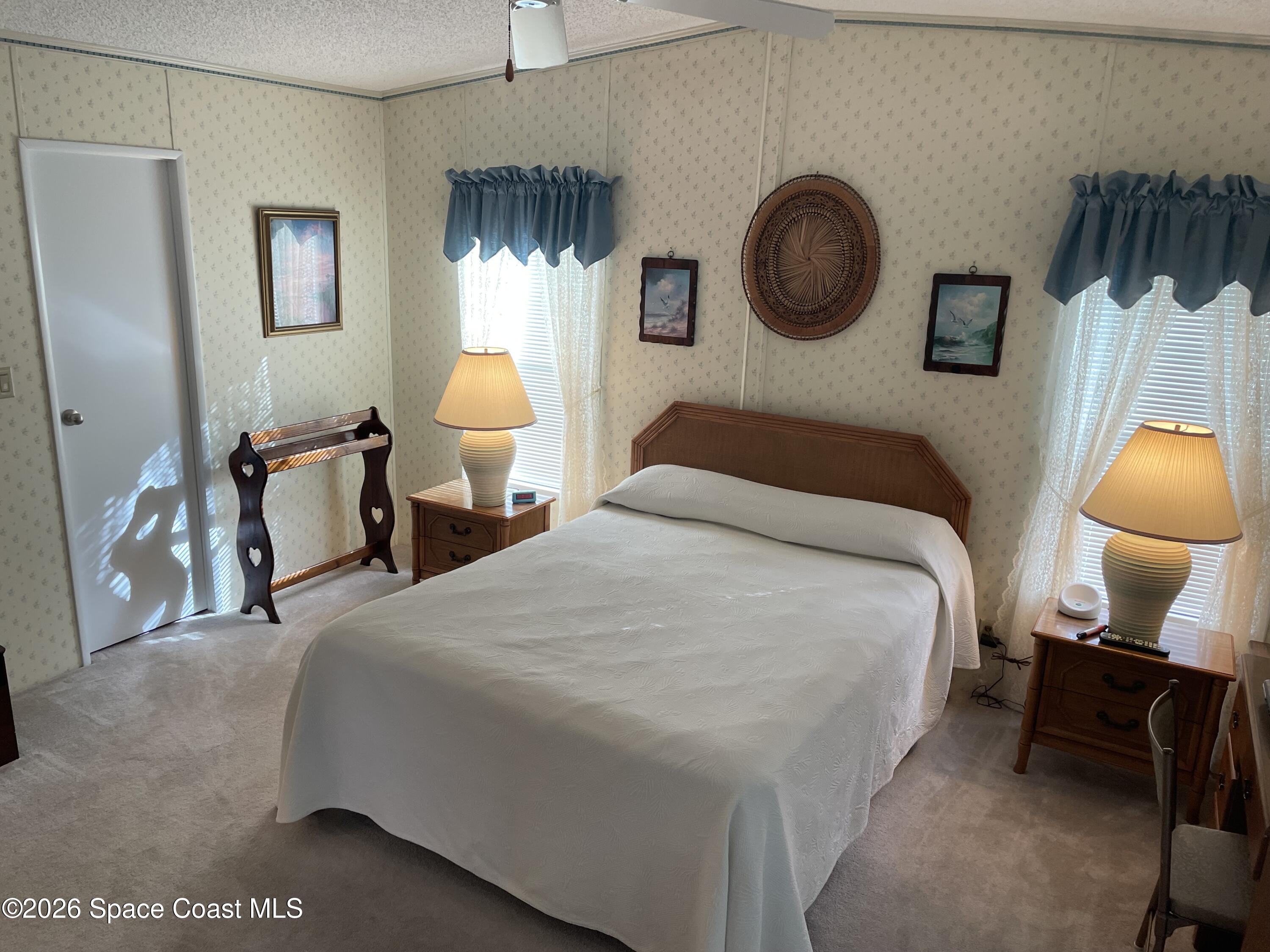 7579 Boxelder Road Micco, FL 32976 - Photo 12 of 30 a bedroom with a bed and a lamp on dresser