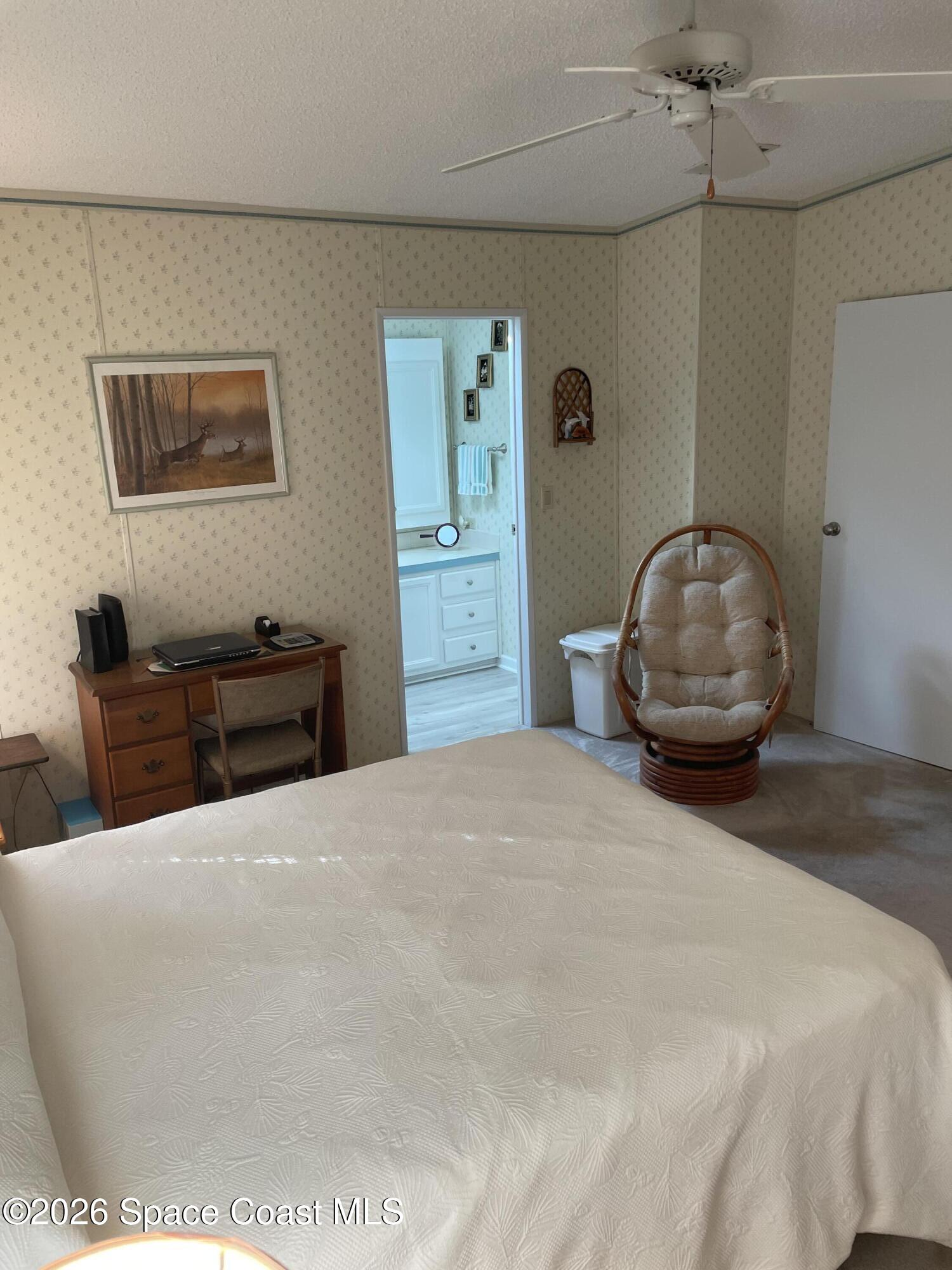 7579 Boxelder Road Micco, FL 32976 - Photo 13 of 30 a bedroom with a large bed and a chandelier