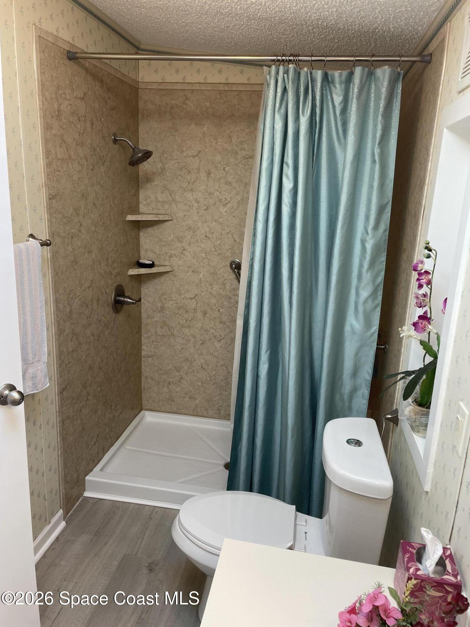 7579 Boxelder Road Micco, FL 32976 - Photo 15 of 30 a bathroom with a shower curtain and a toilet