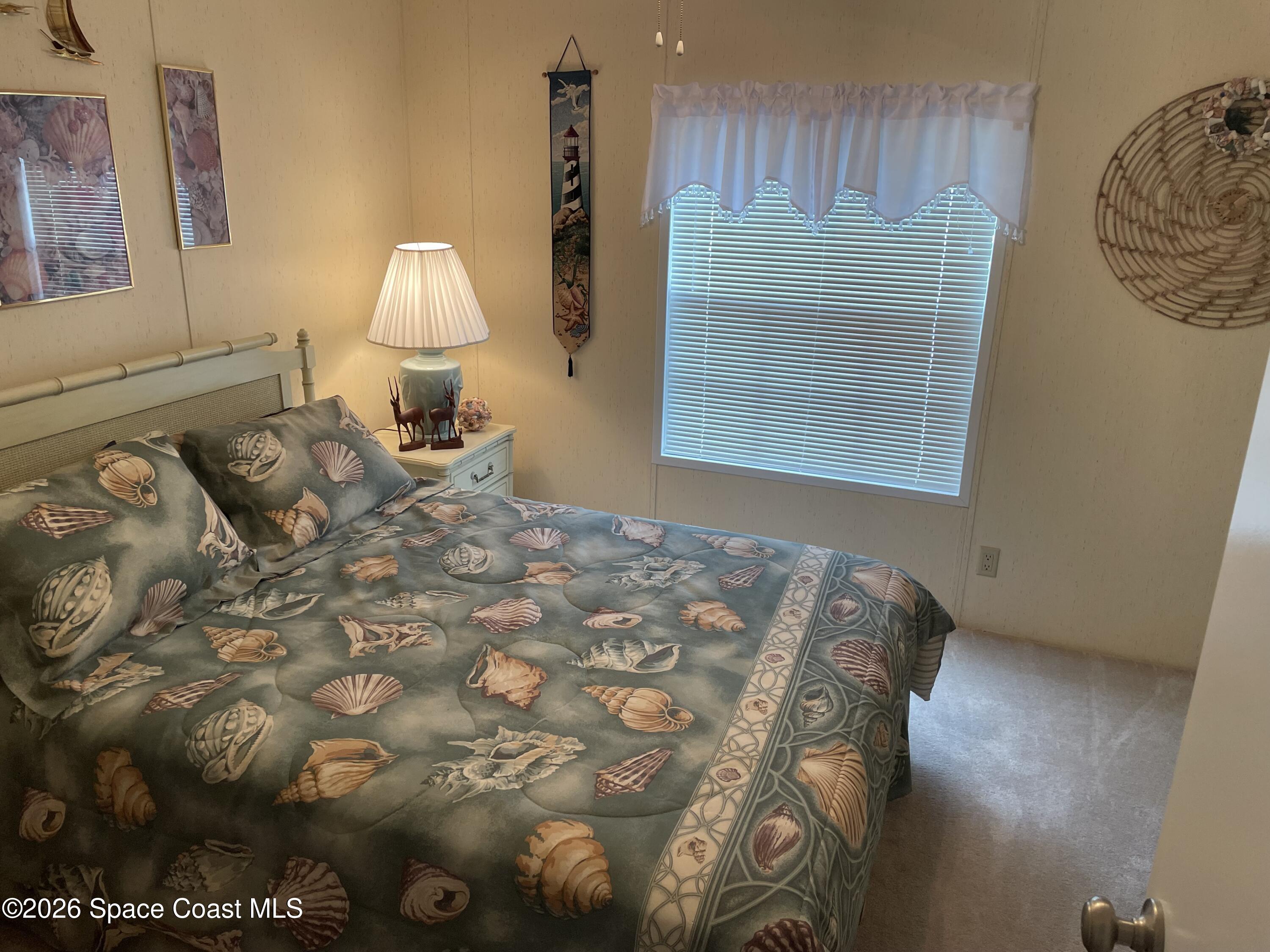7579 Boxelder Road Micco, FL 32976 - Photo 17 of 30 a bedroom with a bed and a lamp on dresser