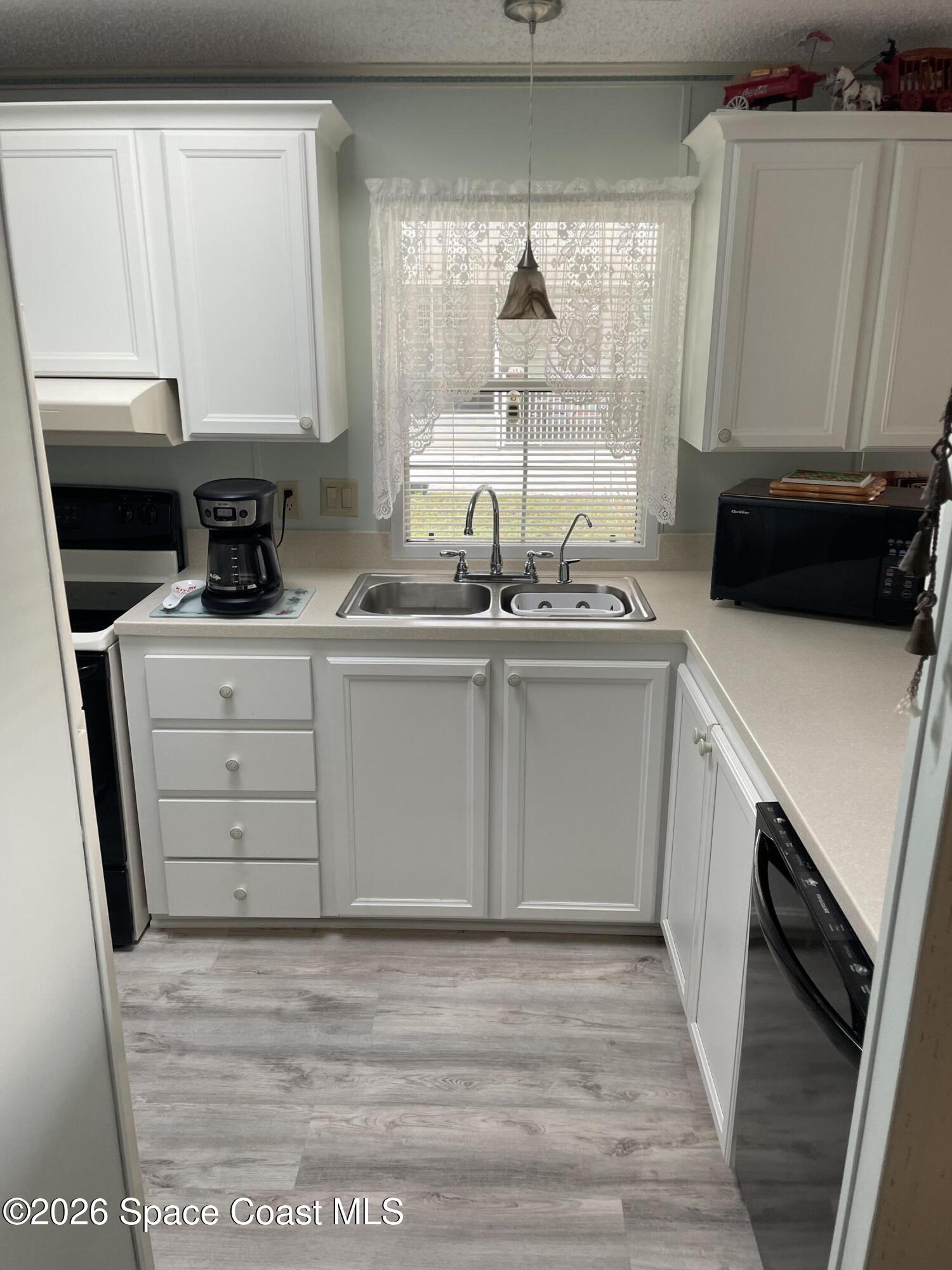 7579 Boxelder Road Micco, FL 32976 - Photo 2 of 30 a kitchen with a sink a stove and cabinets
