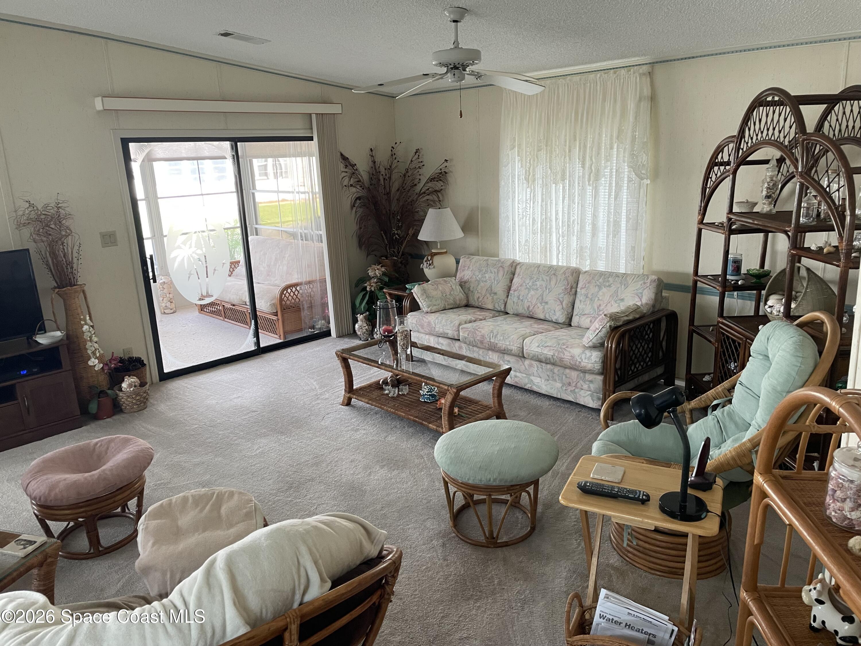 7579 Boxelder Road Micco, FL 32976 - Photo 3 of 30 a living room with furniture a rug and a window