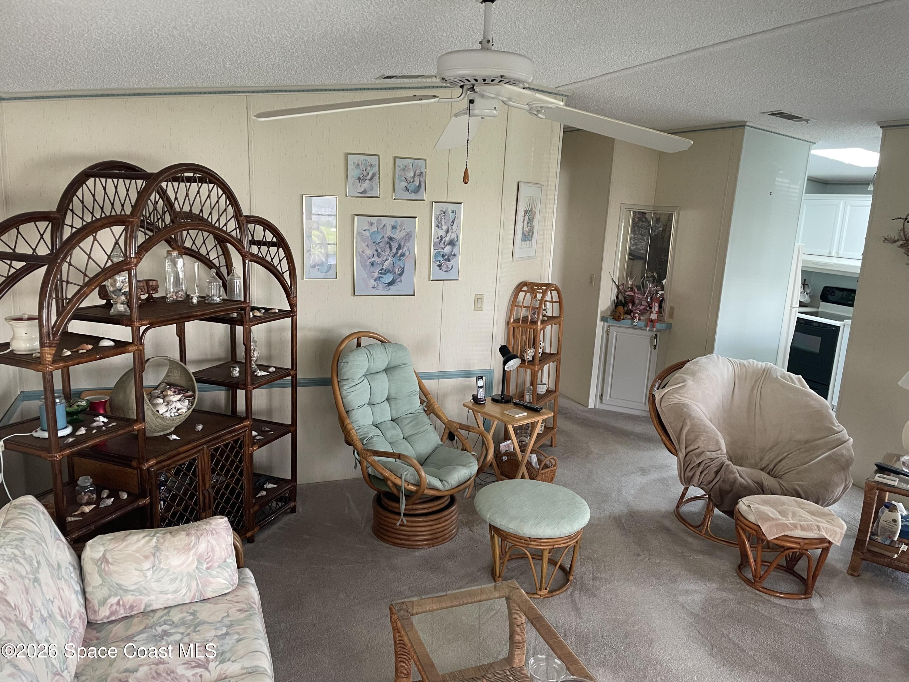 7579 Boxelder Road Micco, FL 32976 - Photo 6 of 30 a living room with furniture and a chandelier
