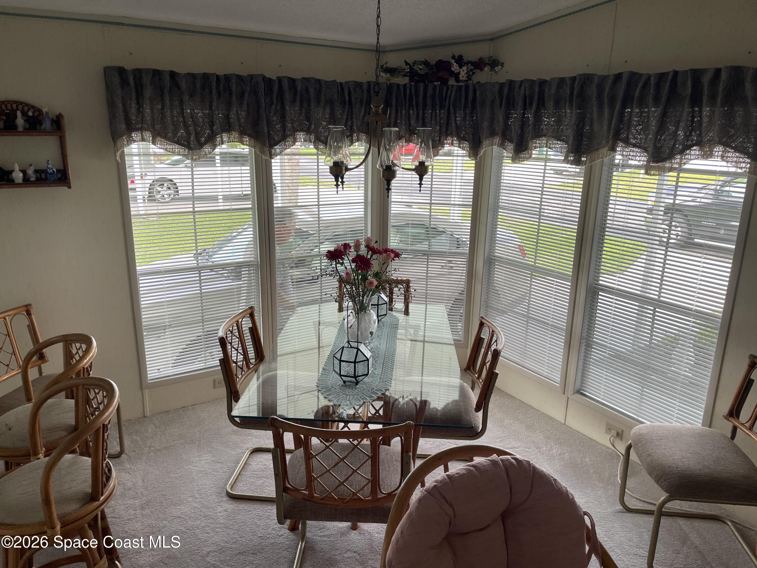 7579 Boxelder Road Micco, FL 32976 - Photo 8 of 30 a dining room with furniture a chandelier and glass door