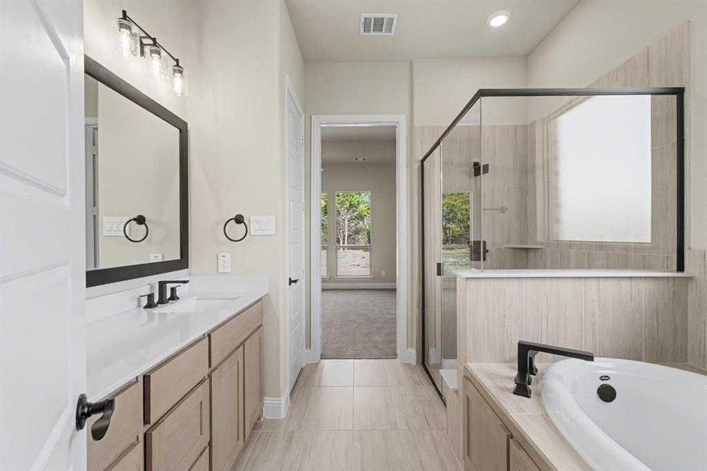 7041 Champion Road Midlothian, TX 76065 - Photo 15 of 30 a bathroom with a tub a sink and mirror