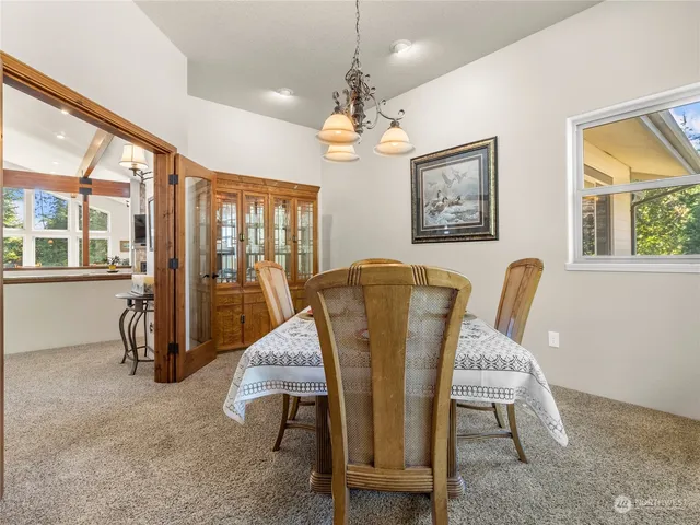 a dining room with furniture a chandelier and window
