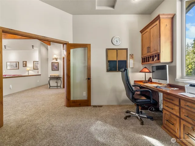 a view of a workspace with furniture and a window