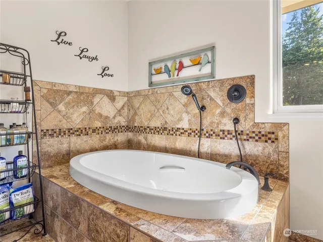 a white bath tub sitting in a bathroom next to a window