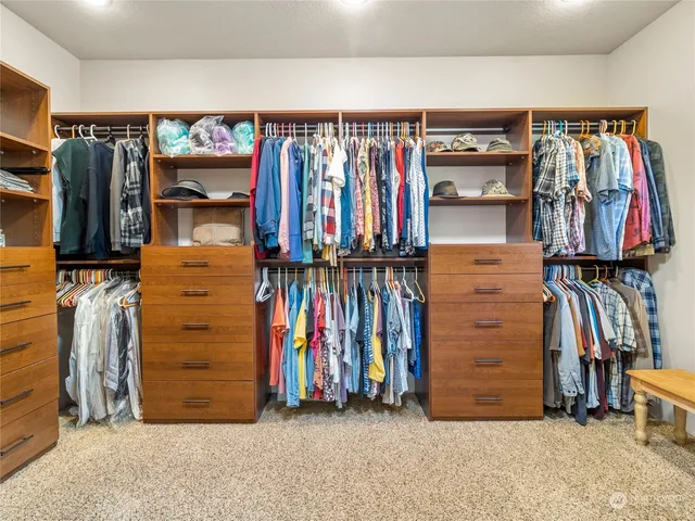 a view of walk in closet with clothes and shoes
