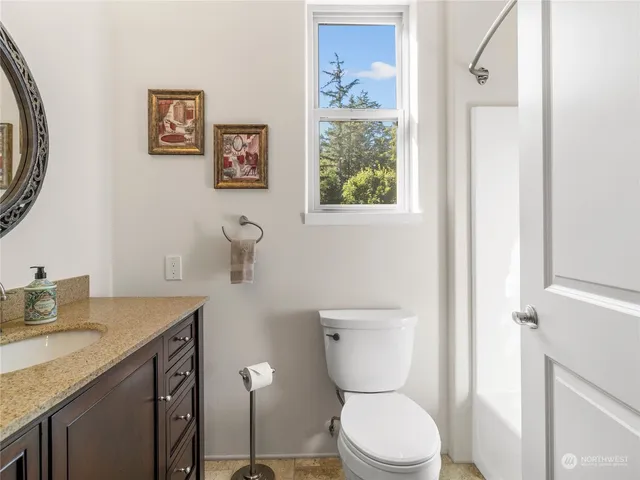 a bathroom with a granite countertop toilet sink and mirror