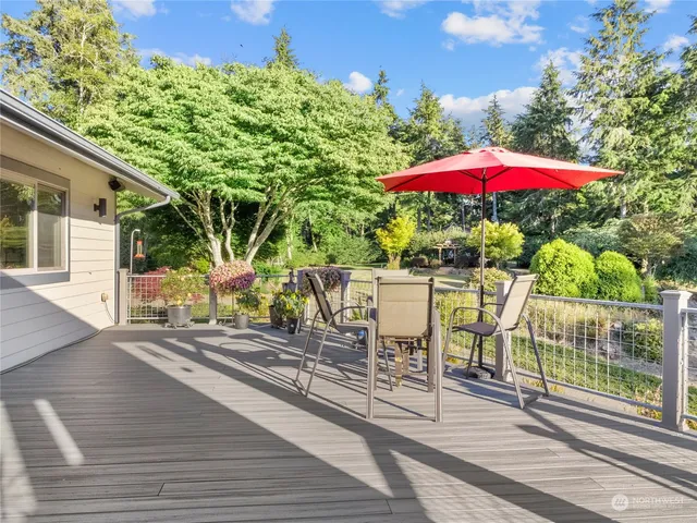 a view of a patio with table and chairs under an umbrella with wooden floor
