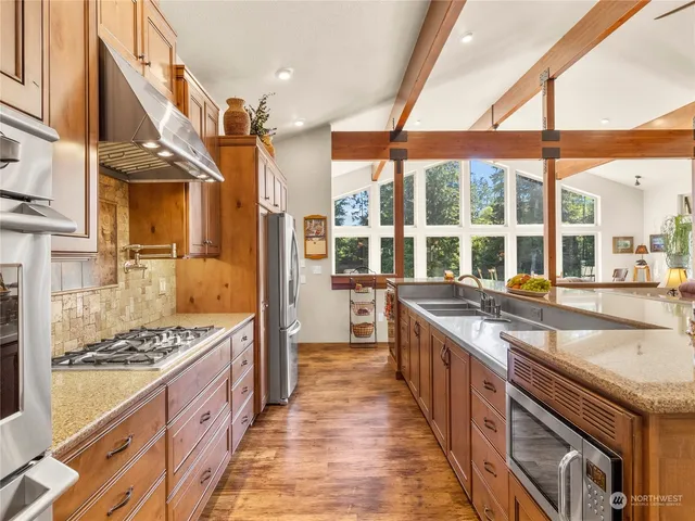 a kitchen with stainless steel appliances kitchen island granite countertop a sink and cabinets