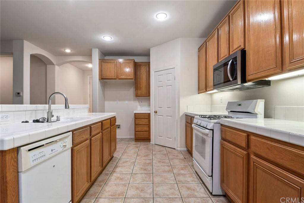 32175 Beaulieu Road Winchester, CA 92596 - Photo 11 of 31 a kitchen with stainless steel appliances granite countertop a sink stove and refrigerator