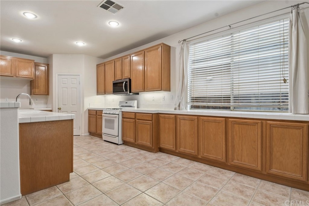 32175 Beaulieu Road Winchester, CA 92596 - Photo 14 of 31 a kitchen with stainless steel appliances granite countertop a stove a sink and a microwave