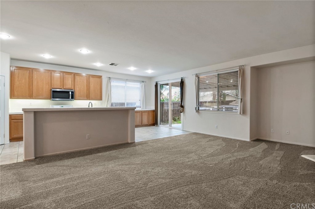 32175 Beaulieu Road Winchester, CA 92596 - Photo 10 of 31 a view of kitchen with kitchen island wooden cabinets and refrigerator