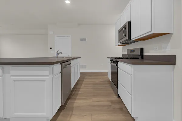 a kitchen with stainless steel appliances a sink stove top oven and cabinets