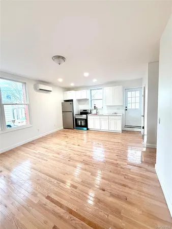 a view of empty room with kitchen and window