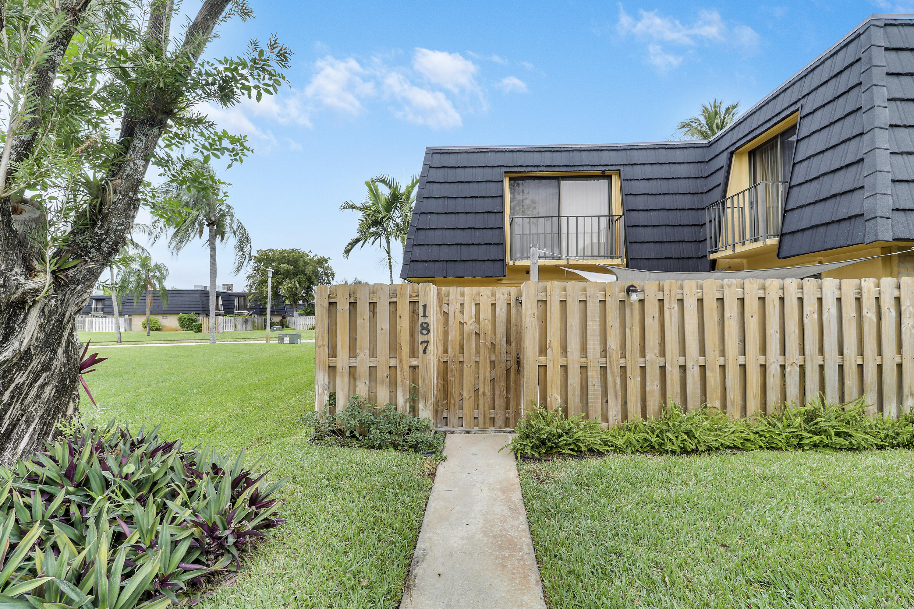 187 Woodland Road Palm Springs, FL 33461 - Photo 2 of 29 a front view of a house with garden