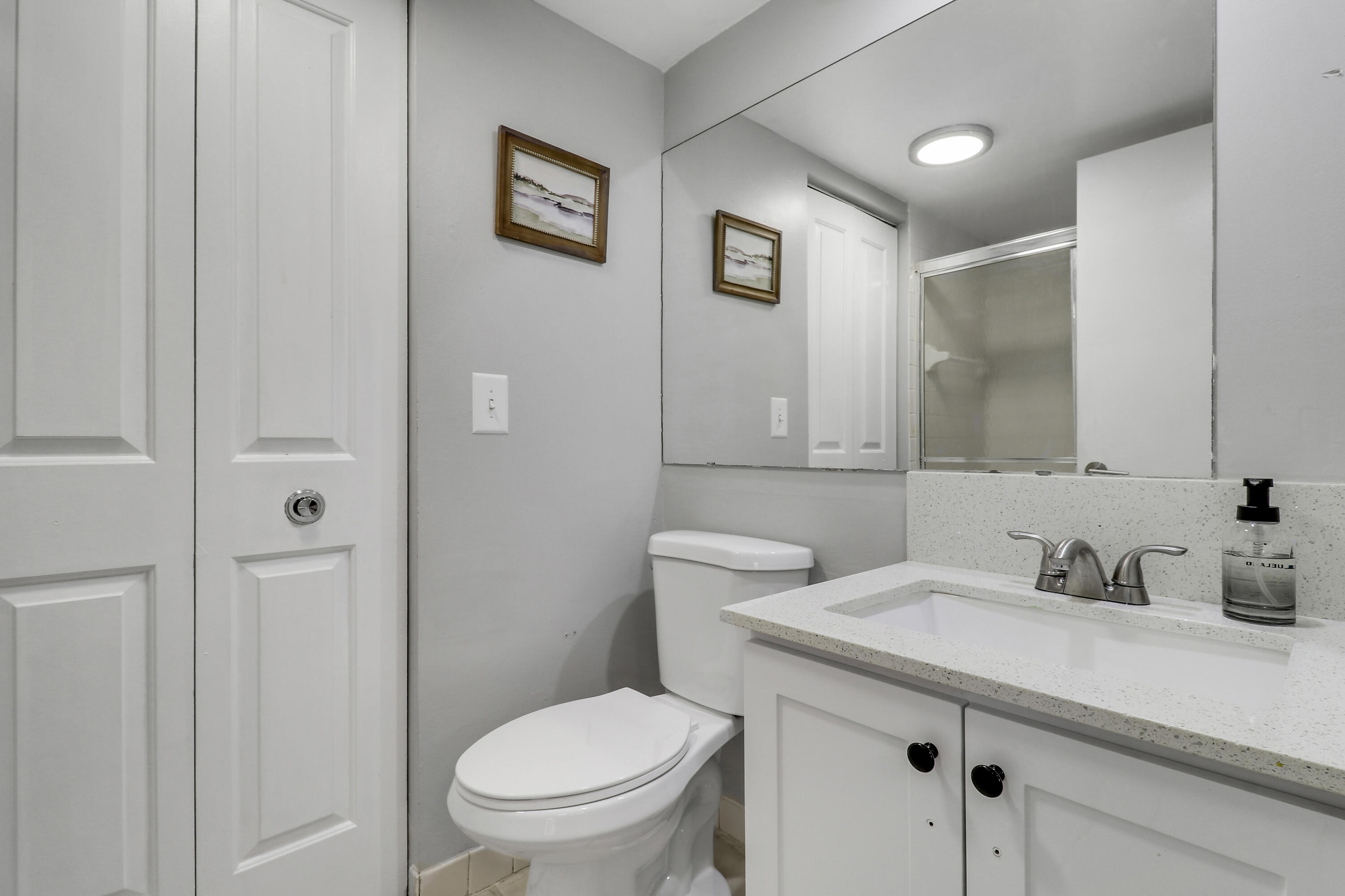 187 Woodland Road Palm Springs, FL 33461 - Photo 28 of 29 a bathroom with a toilet sink and mirror