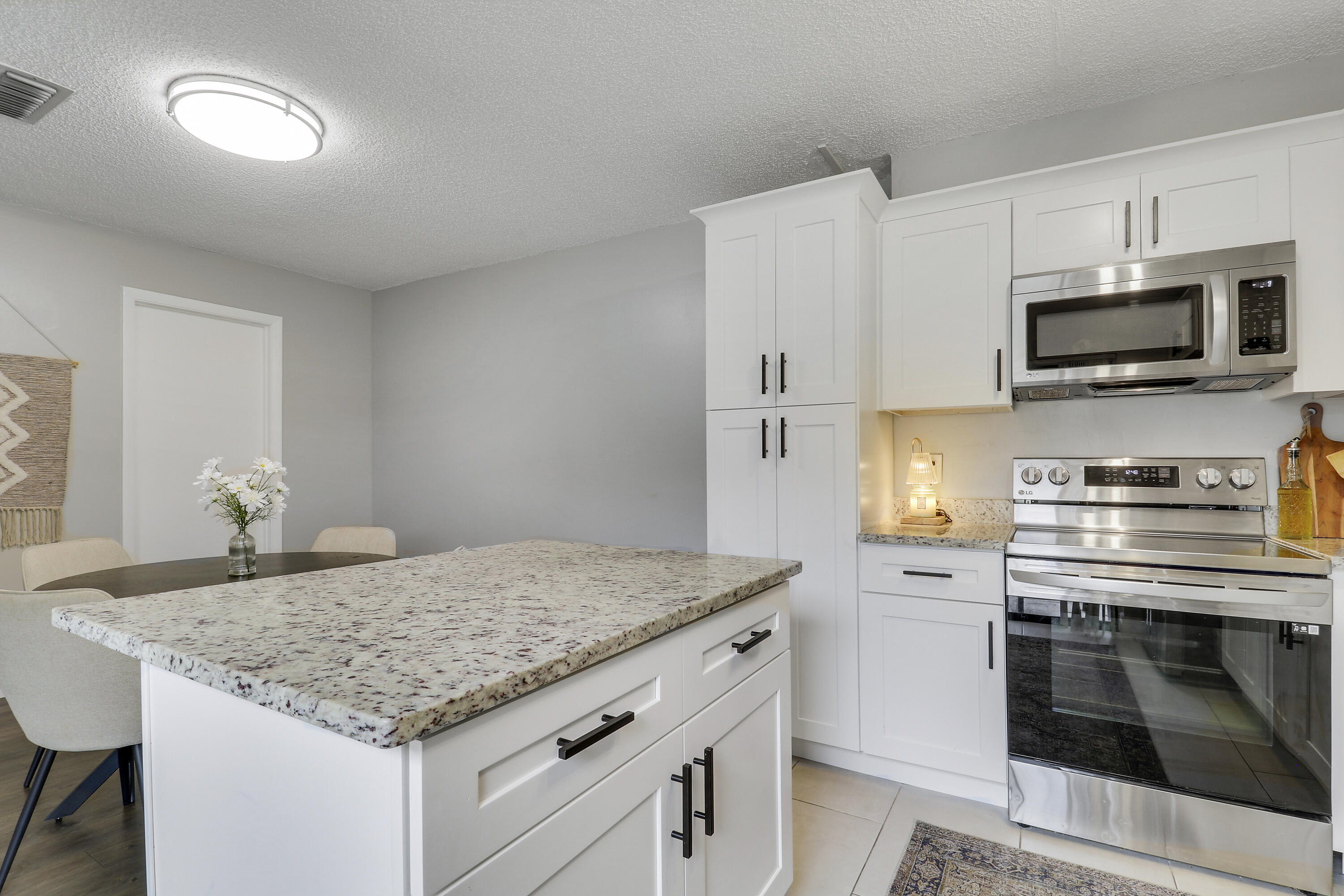 187 Woodland Road Palm Springs, FL 33461 - Photo 8 of 29 a kitchen with granite countertop a sink dishwasher stove and oven with wooden floor