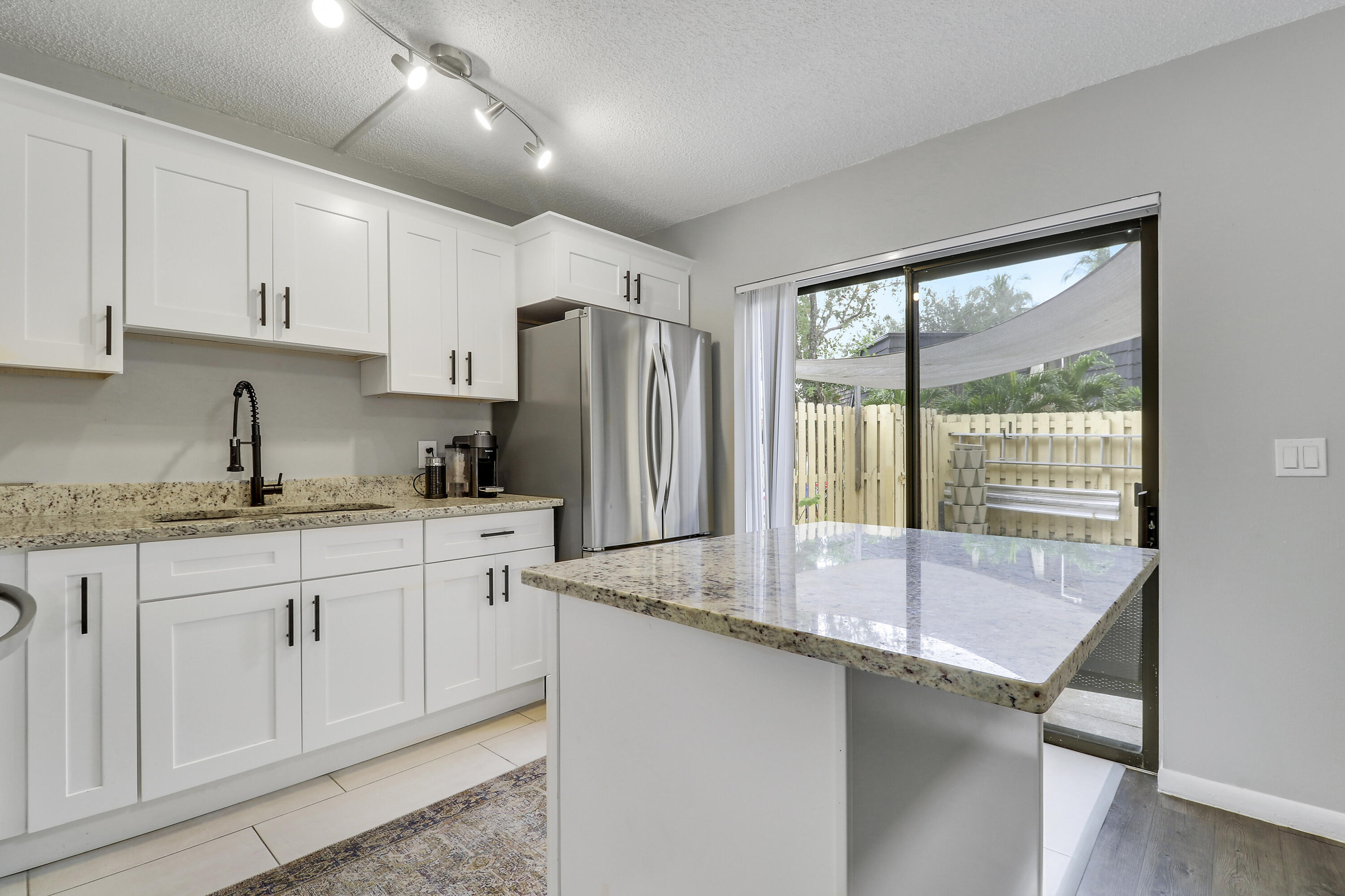 187 Woodland Road Palm Springs, FL 33461 - Photo 9 of 29 a kitchen with granite countertop a sink and a refrigerator