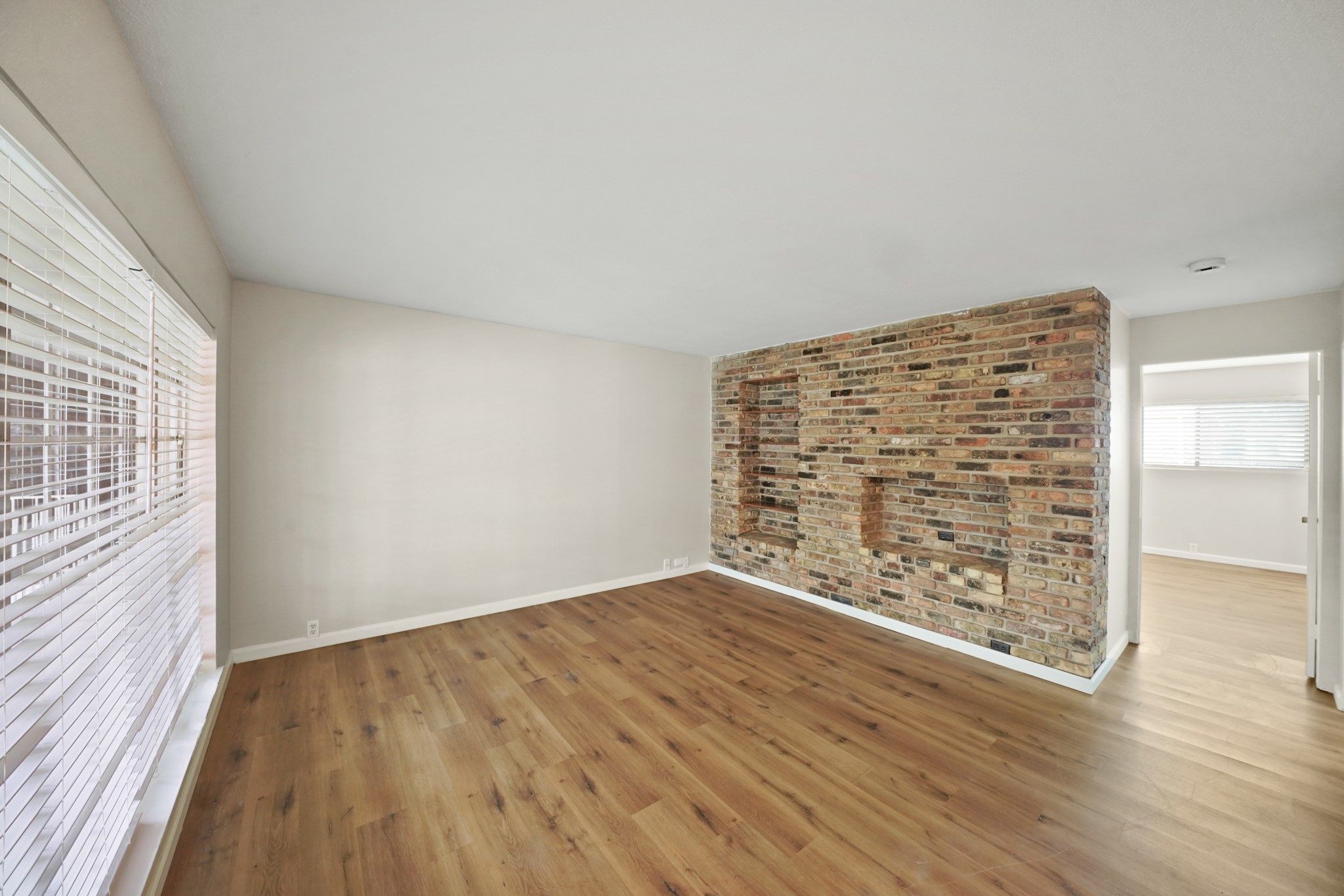 2201 Fountain View Drive, Unit 60F Houston, TX 77057 - Photo 4 of 18 wooden floor in an empty room with a window