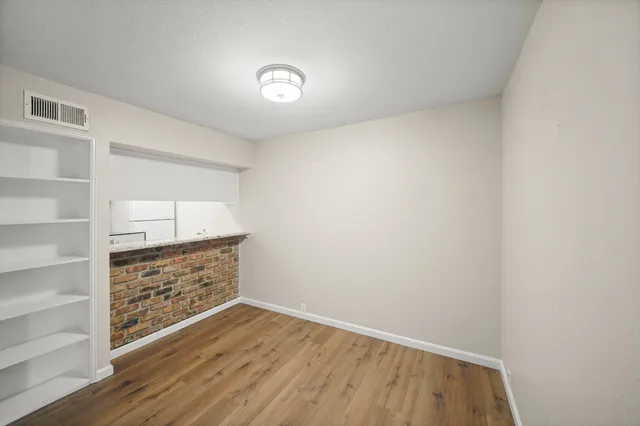 a view of an empty room with cabinet and stairs