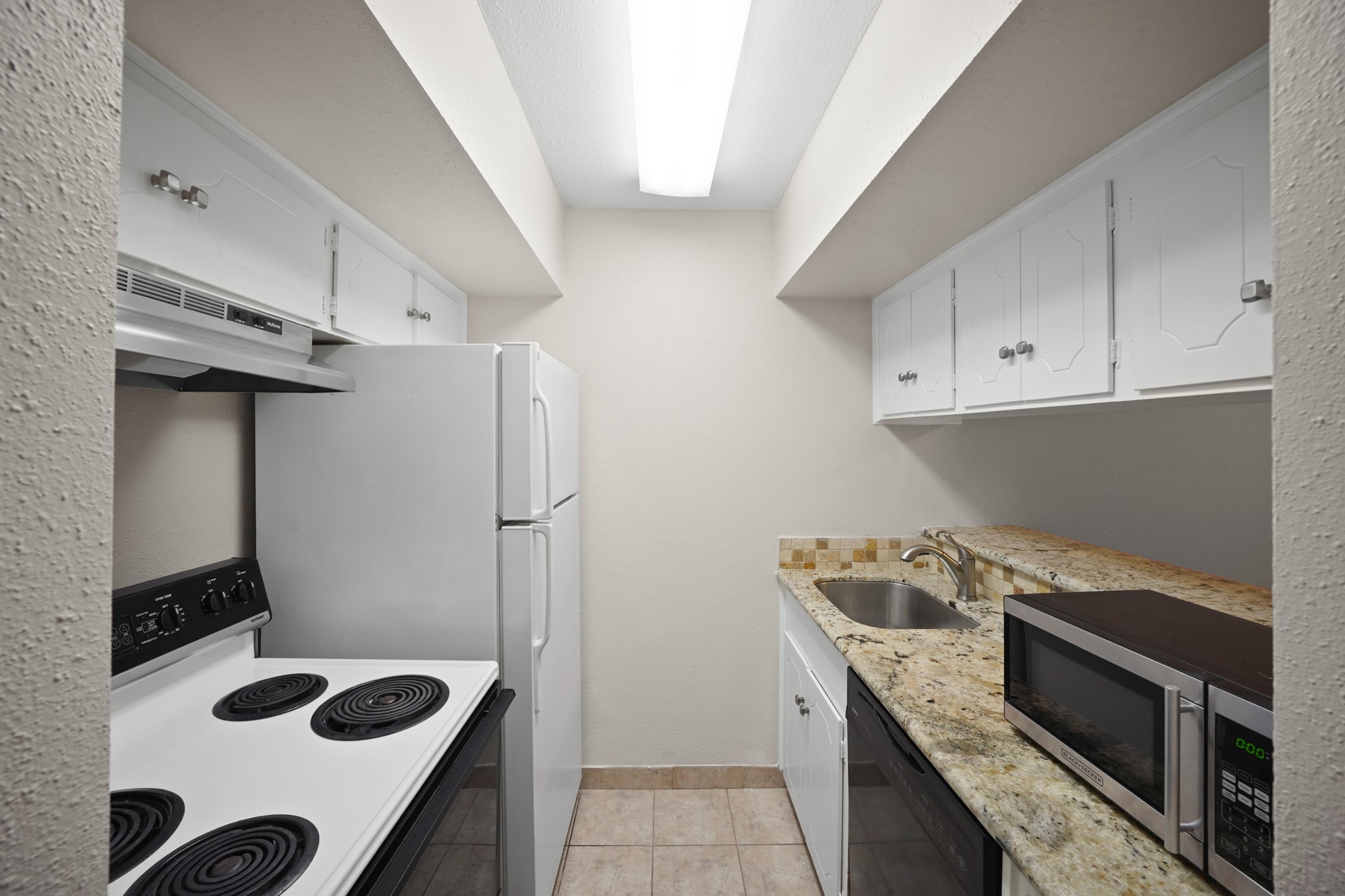 2201 Fountain View Drive, Unit 60F Houston, TX 77057 - Photo 9 of 18 a kitchen with a stove and a refrigerator