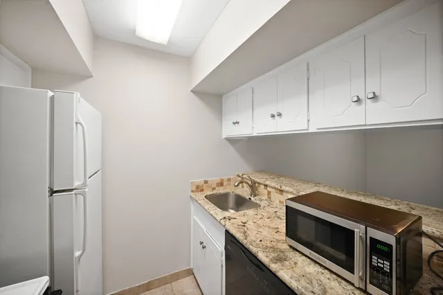 a kitchen with stainless steel appliances granite countertop a refrigerator and a stove