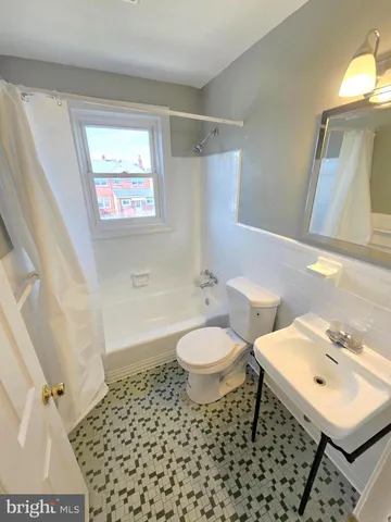 a bathroom with a sink toilet a mirror and shower