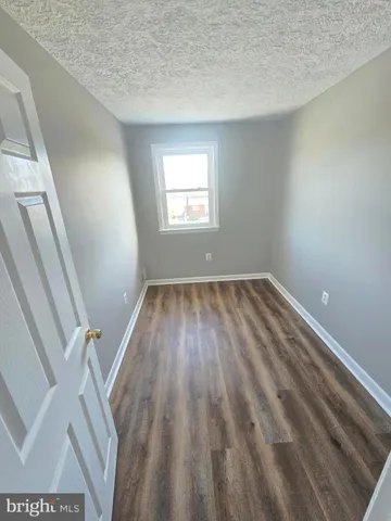 a view of a room with wooden floor and windows