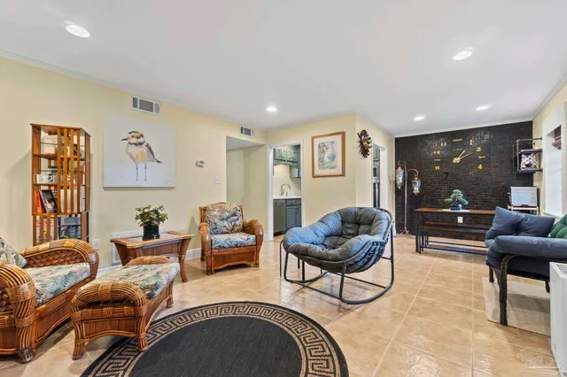 a living room with furniture a lamp and a potted plant