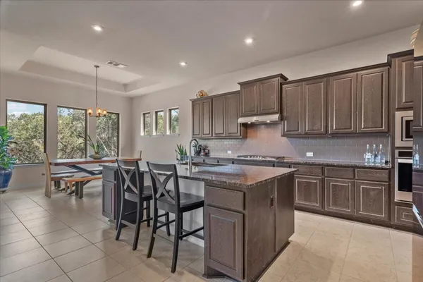 a large kitchen with kitchen island a large window in it