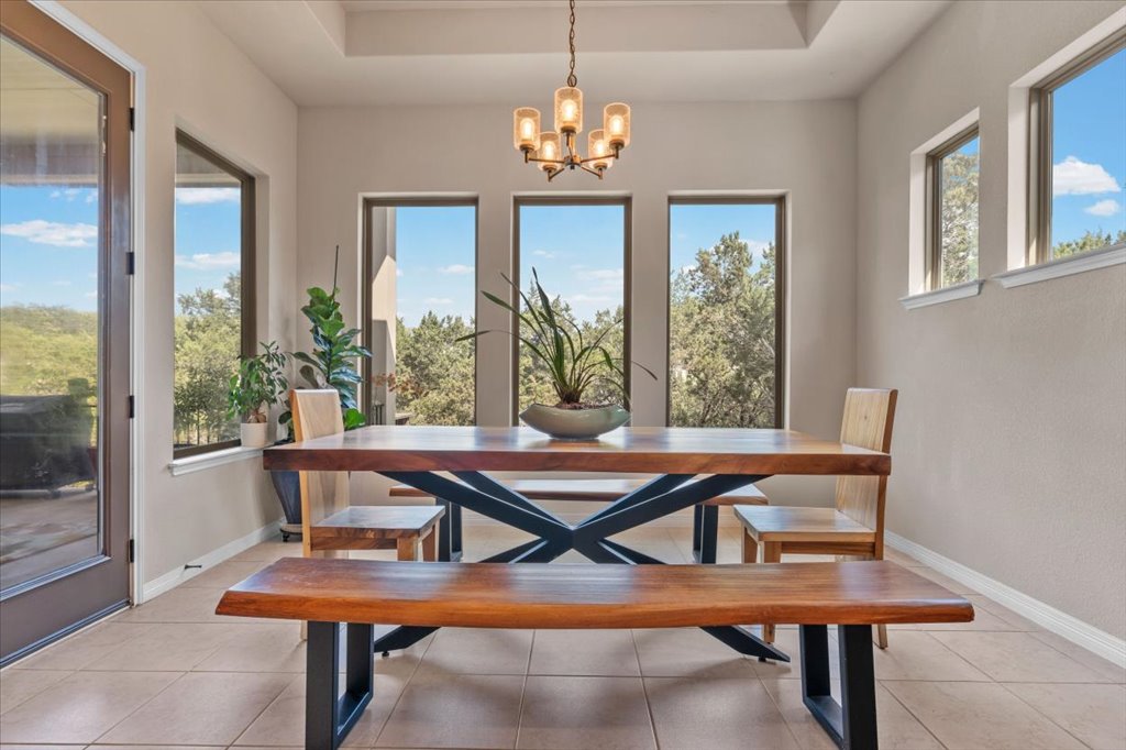 6705 Destination Way Jonestown, TX 78645 - Photo 14 of 39 Surrounded by tall windows, this dining space feels like you are in a treehouse, with panoramic views of the lush Texas Hill Country greenery.