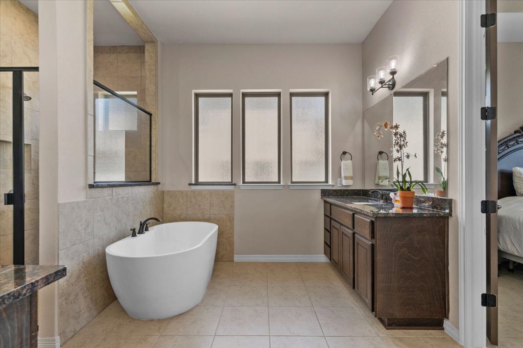 6705 Destination Way Jonestown, TX 78645 - Photo 18 of 39 Separate vanities and a walk in closet complete this ensuite.