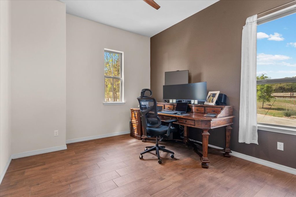 6705 Destination Way Jonestown, TX 78645 - Photo 21 of 39 The rich wood look flooring paired with a view of the Texas landscape make this a quiet, relaxing space.