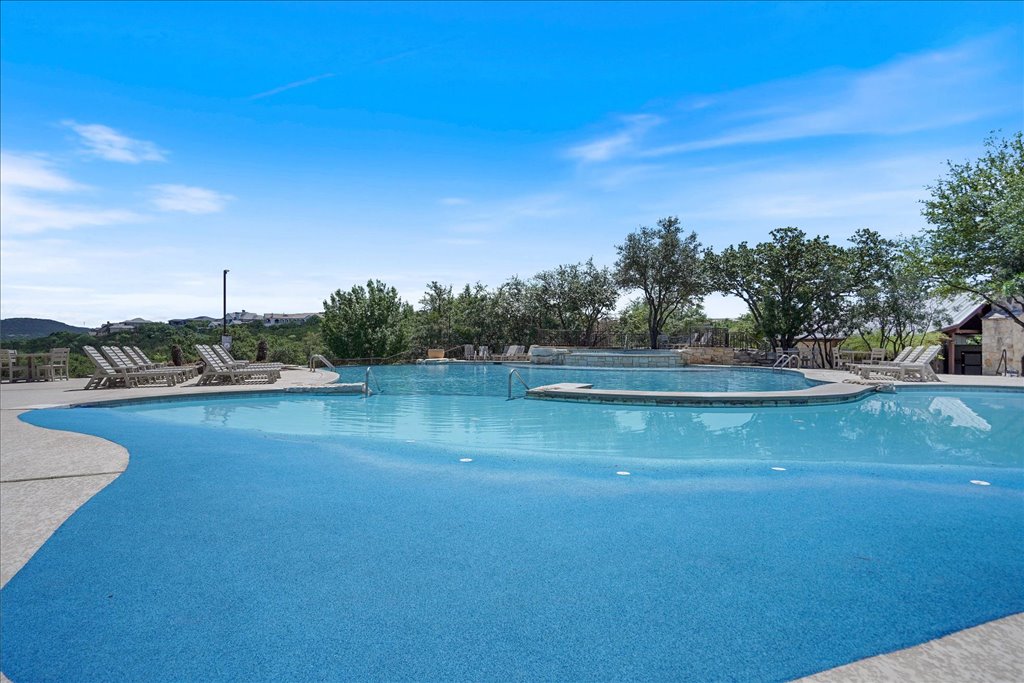 6705 Destination Way Jonestown, TX 78645 - Photo 36 of 39 Zero-entry bliss. The crystal-clear blue water of the community pool seems to melt into the horizon. Whether you're swimming laps or just wading in, the view of the surrounding hills provides a peaceful backdrop that’s hard to beat.