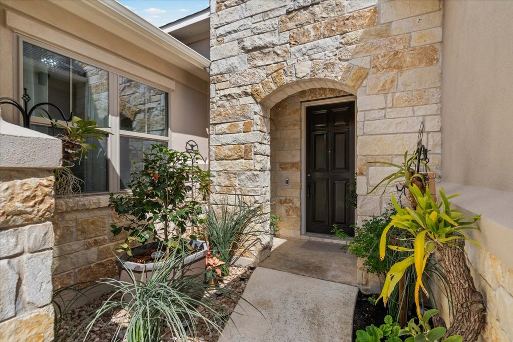 6705 Destination Way Jonestown, TX 78645 - Photo 4 of 39 The arched stone portico creates a private, shaded entry into the home.